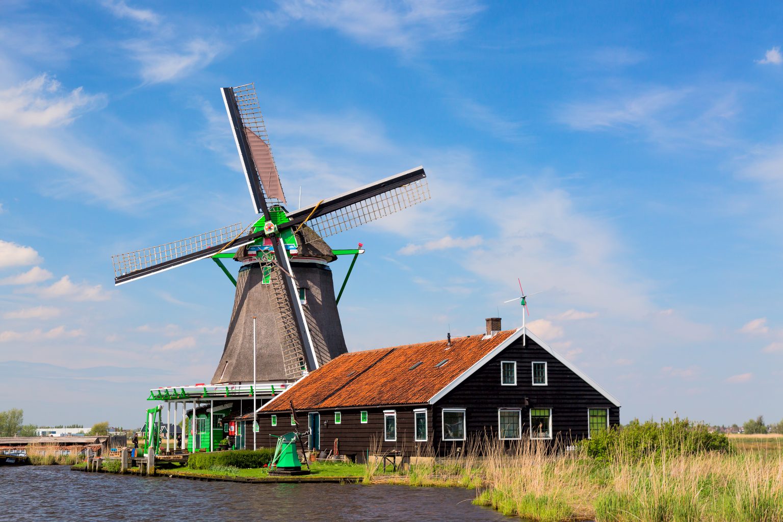 Windmill and green wooden house on the Zaan